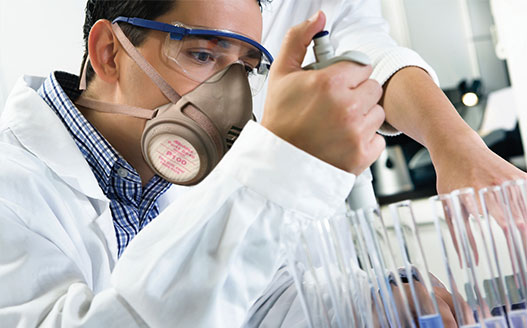 technician working in laboratory wearing ear and eye protection